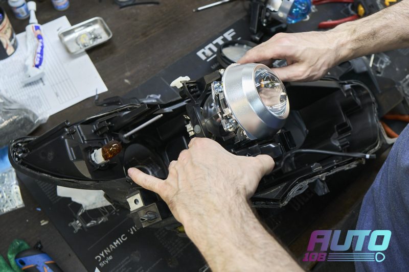 Мастер устанавливает Bi-LED модуль в корпус фары Mazda 6 GJ