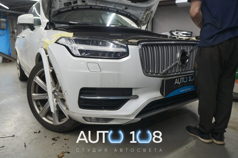Мастер снимает бампер Volvo XC90 II для демонтажа фар