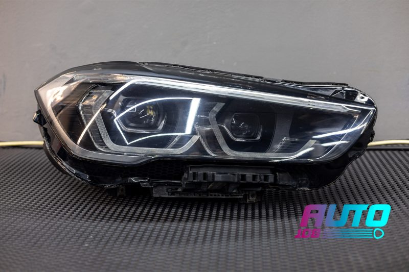 Собранная фара BMW X1 F48 на столе — стекло сухое, горят ДХО