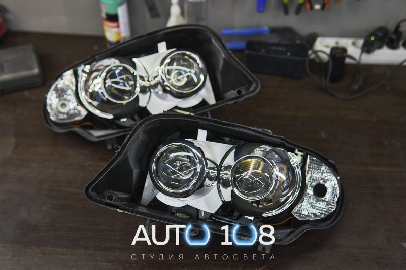 Две вскрытые фары BMW E90 без стёкол — штатные линзы и маски внутри