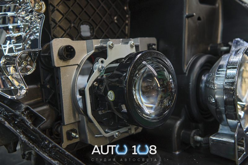 Линза Aozoom A3+ в переходной рамке внутри фары Mitsubishi Pajero 4