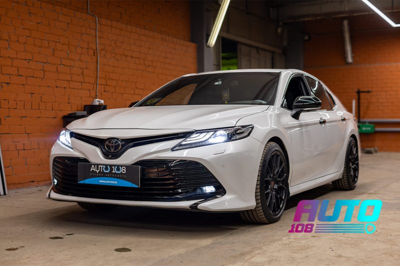 Белая Toyota Camry 70 с включёнными фарами после улучшения света