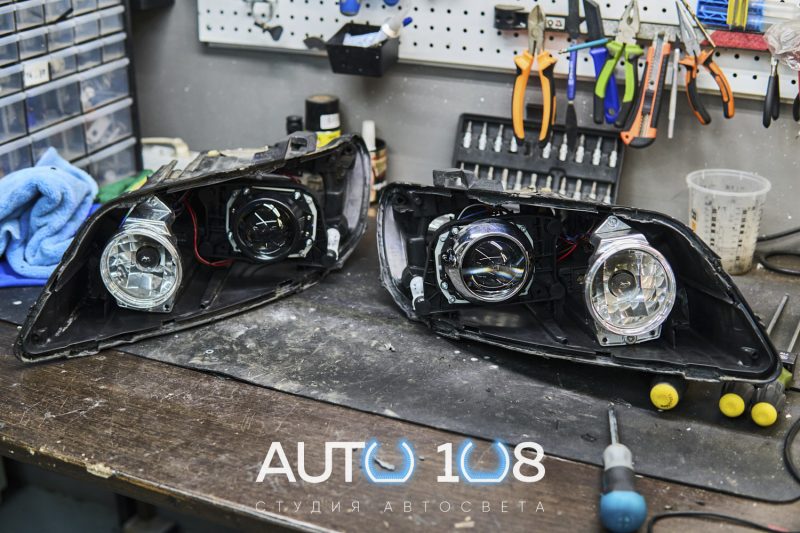 Две вскрытые фары Audi Q7 4L: сравнение штатной и новой Bi-LED линзы