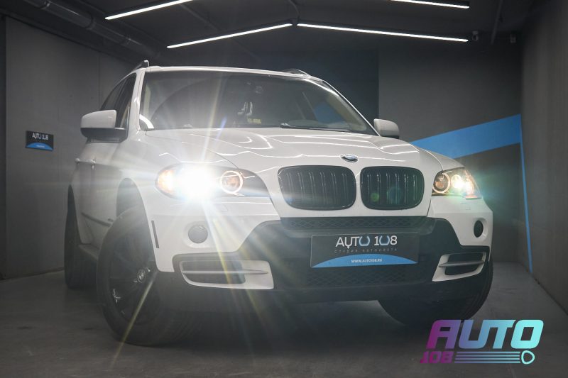 Белый BMW X5 E70 с включённым светом Bi-LED после работ в «Авто-108»